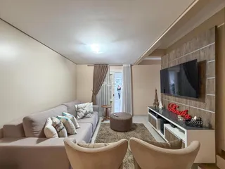 Sala de estar com sofá e poltronas em um apartamento em Lajeado.