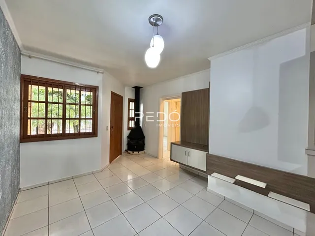 Sala de estar com piso de cerâmica e janela de madeira.