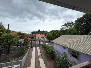 Vista externa da propriedade em Lajeado, Brasil, mostrando o acesso e a área de jardim.