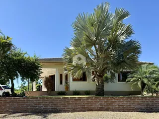 Fachada de uma residência em Lajeado, Brasil, com vegetação exuberante na frente.