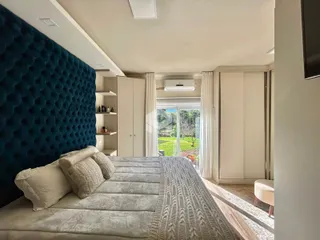 Quarto com cabeceira azul e armários em um ambiente interno.