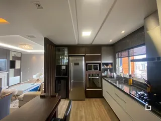 Sala de estar com piso de madeira e armários embutidos.