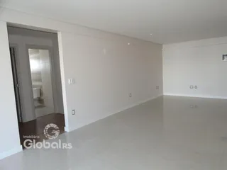 Um corredor amplo com paredes brancas e piso claro.
