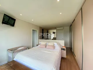 Quarto com cama e armários em ambiente claro.