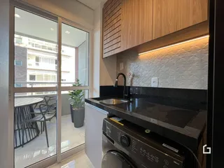 Vista da cozinha com portas de vidro que dão acesso a uma área externa.