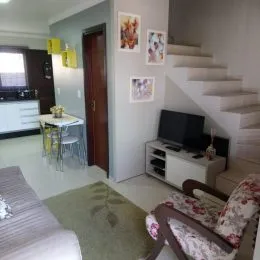 Quarto com cama e escada visível em ambiente interno.