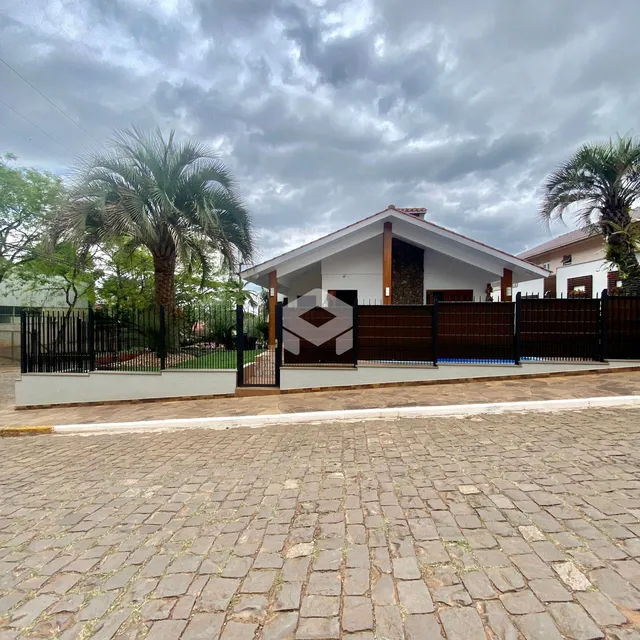 Fachada de uma casa em Lajeado, Brasil, com cerca e portão de madeira.