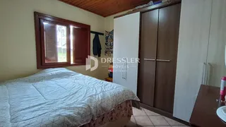 Quarto com cama grande e janela de madeira em um imóvel no Brasil.