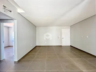 Corredor interno de uma residência com piso de cerâmica e paredes brancas.