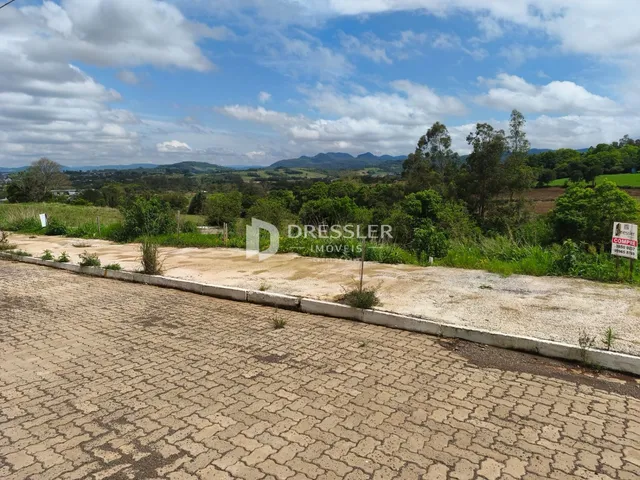 Vista panorâmica de paisagem rural com colinas e vegetação ao fundo.
