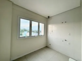 Sala com grande janela mostrando a paisagem urbana da cidade.