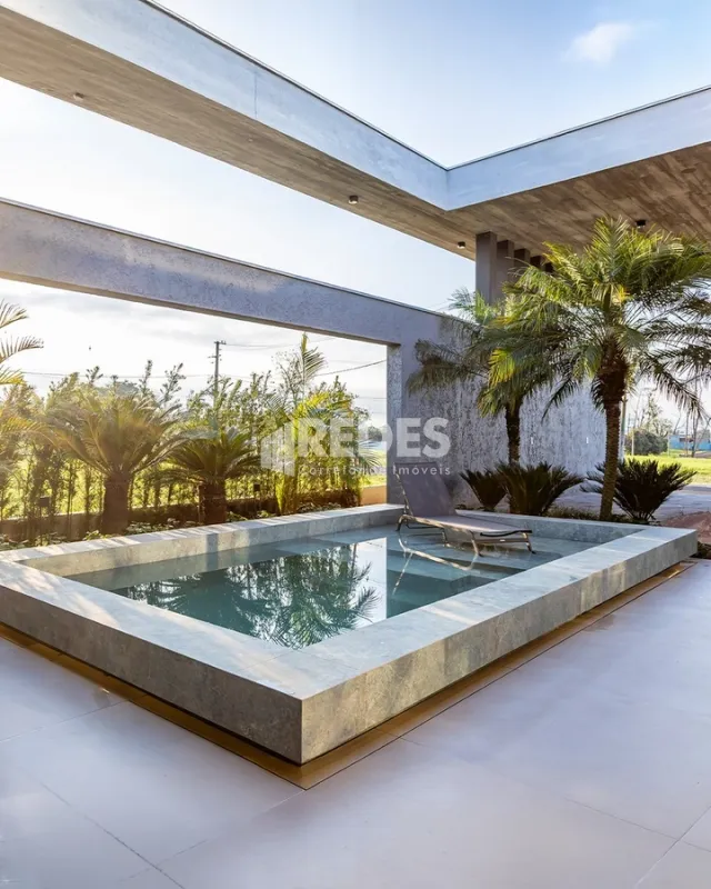Vista externa de uma piscina retangular em uma área de lazer.