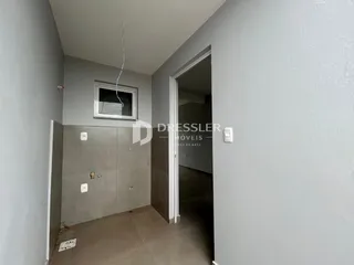 Hall de entrada com parede cinza e porta aberta em imóvel no Brasil