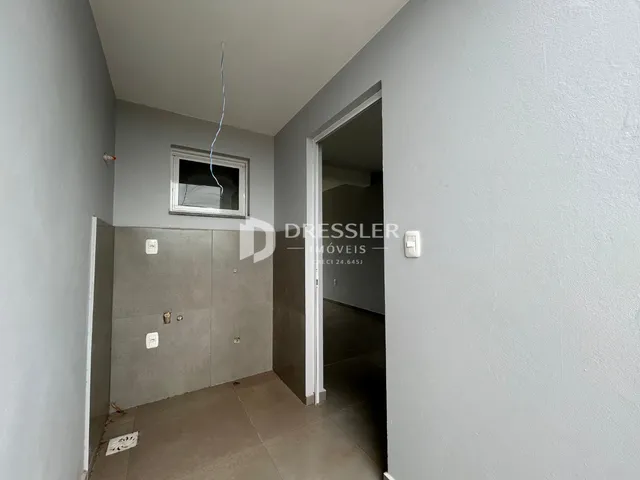 Hall de entrada com parede cinza e porta aberta em imóvel no Brasil