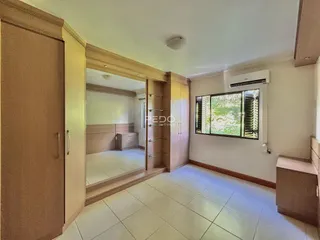 Hall de entrada com armários e piso de cerâmica claro.