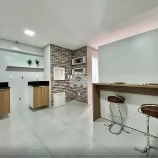 Interior da cozinha com piso de cerâmica e parede de tijolos expostos.