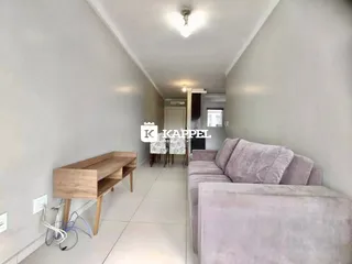 Corredor interno com sofá e móvel de madeira em um imóvel.