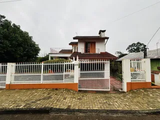Fachada de uma casa em Lajeado, Brasil, com cerca branca e portão.