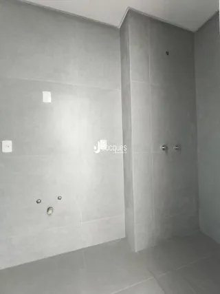Foto de um ambiente interno com paredes brancas e piso claro.