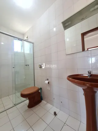 Banheiro com piso e paredes revestidos em cerâmica branca.