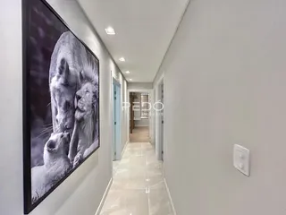 Corredor interno de uma residência com paredes brancas.