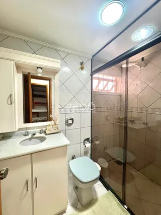 Foto de um banheiro interno com box de vidro e vaso sanitário.