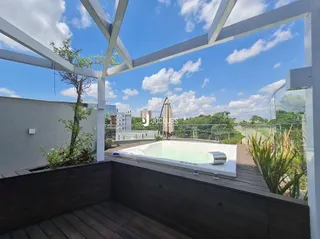 Vista de uma piscina e deck ao ar livre em uma propriedade.