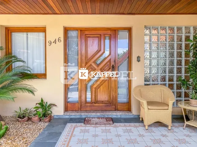 Fachada de uma residência com porta de madeira e jardim na entrada.