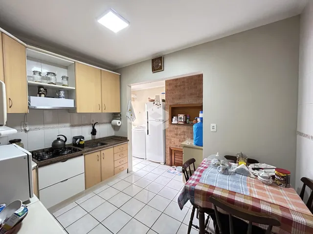 Interior de uma cozinha e sala de jantar com piso de cerâmica.