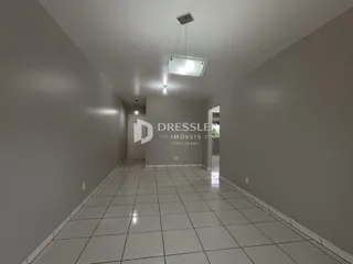 Corredor interno de uma residência com piso de cerâmica branca.
