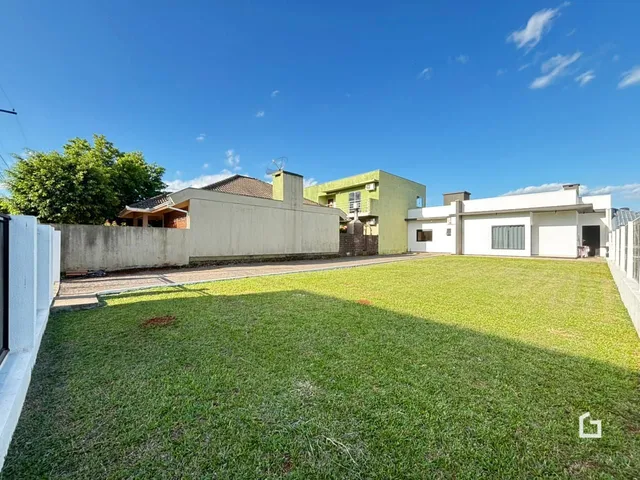 Fachada de uma residência com um grande gramado no quintal em Lajeado.