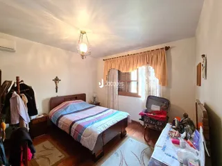 Quarto com cama de madeira e piso de madeira.