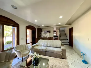 Sala de estar com sofá e poltronas em um imóvel no Brasil.