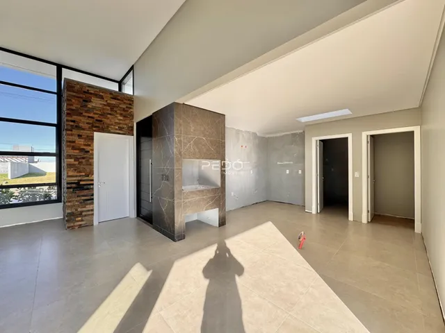 Sala de estar ampla com grande janela e parede de destaque em Lajeado.
