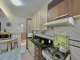 Cozinha com armários de madeira e revestimento cerâmico.