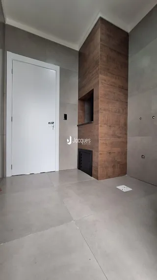 Hall de entrada com porta branca e coluna de tijolo aparente.