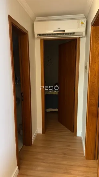 Hall de entrada com portas de madeira e piso de madeira.