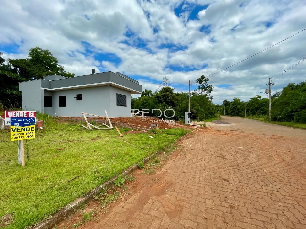 Fachada de uma casa em construção em Lajeado, Brasil, com terreno ao redor.