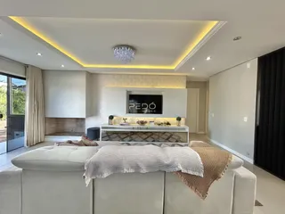 Sala de estar moderna com sofá e iluminação de teto.