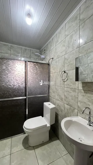 Foto de um banheiro com revestimento cerâmico nas paredes e piso.