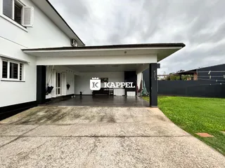 Fachada da casa com uma área coberta e pátio frontal.