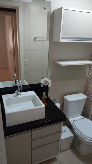 Banheiro com pia e vaso sanitário em um imóvel.