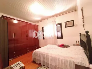 Quarto com armários em madeira e cama de casal.