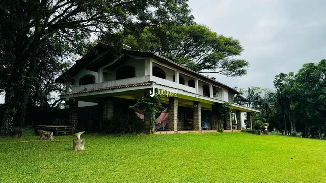 Fachada de uma casa em Lajeado, Brasil, com jardim verde e vegetação exuberante.