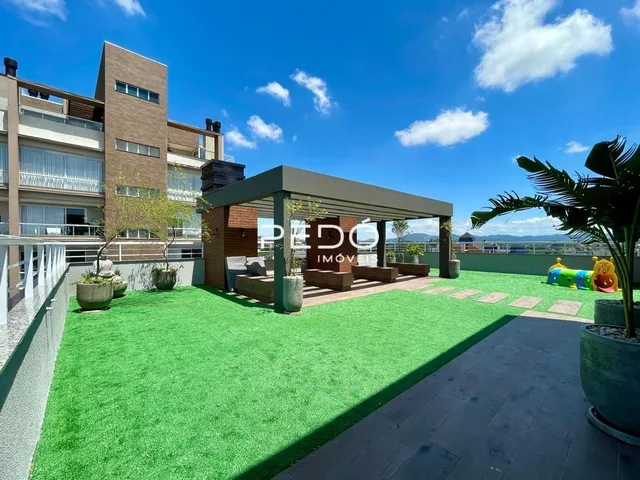 Área externa com gramado e estrutura de pérgola.