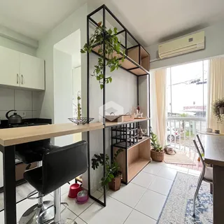 Interior de uma sala de estar com cozinha e vista para a varanda em Lajeado.