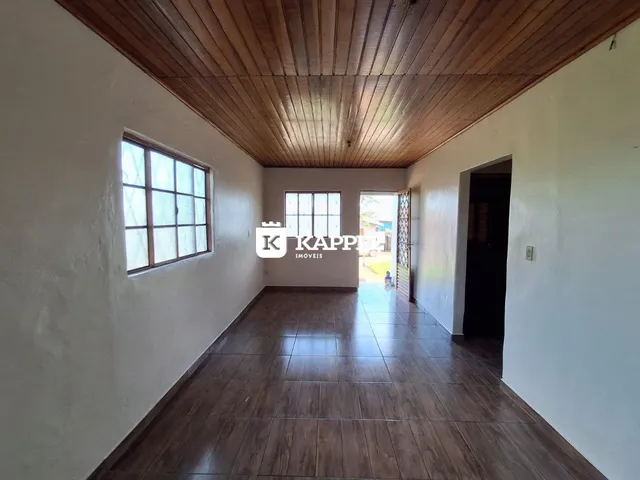 Corredor interno com piso de cerâmica e forro de madeira.