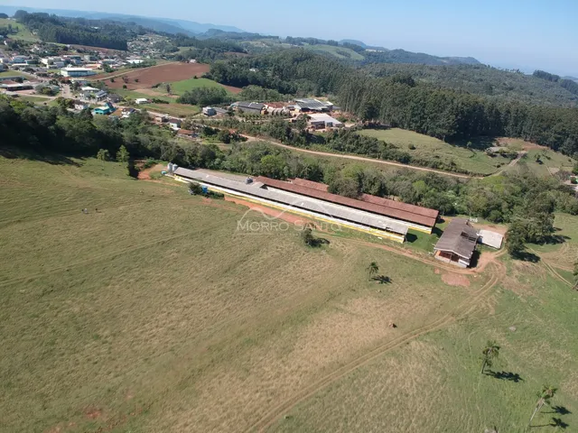 Vista aérea de uma propriedade rural com grandes campos e um complexo de edifícios.