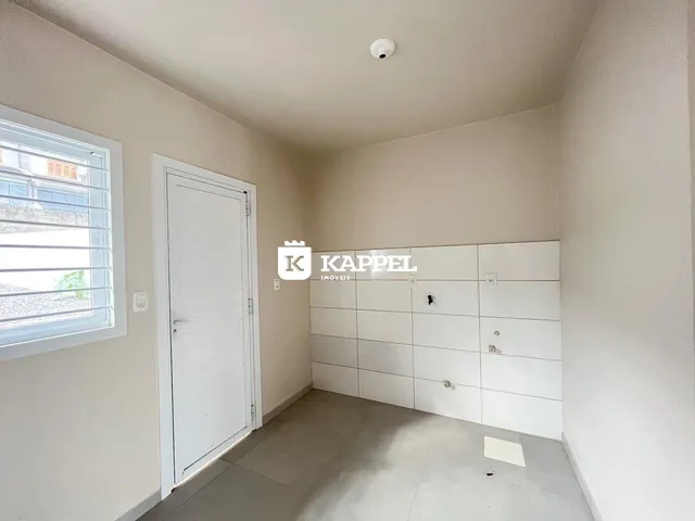 Hall de entrada com porta branca e parede clara em um imóvel.