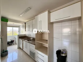 Esta é uma foto de uma cozinha com armários brancos e piso claro.